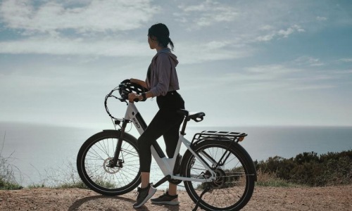 a woman standing next to a bicycle